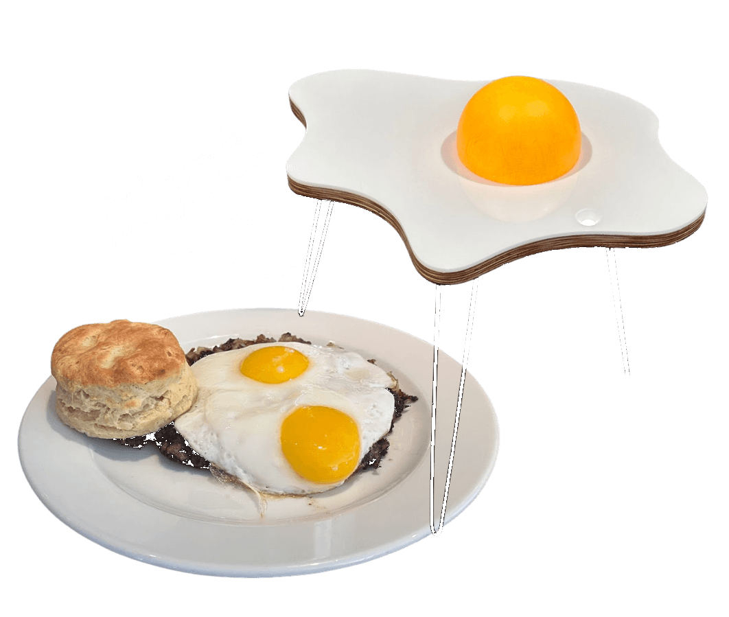 A fried-egg-shaped side table prototype with sunny-side-up eggs on a plate beneath it