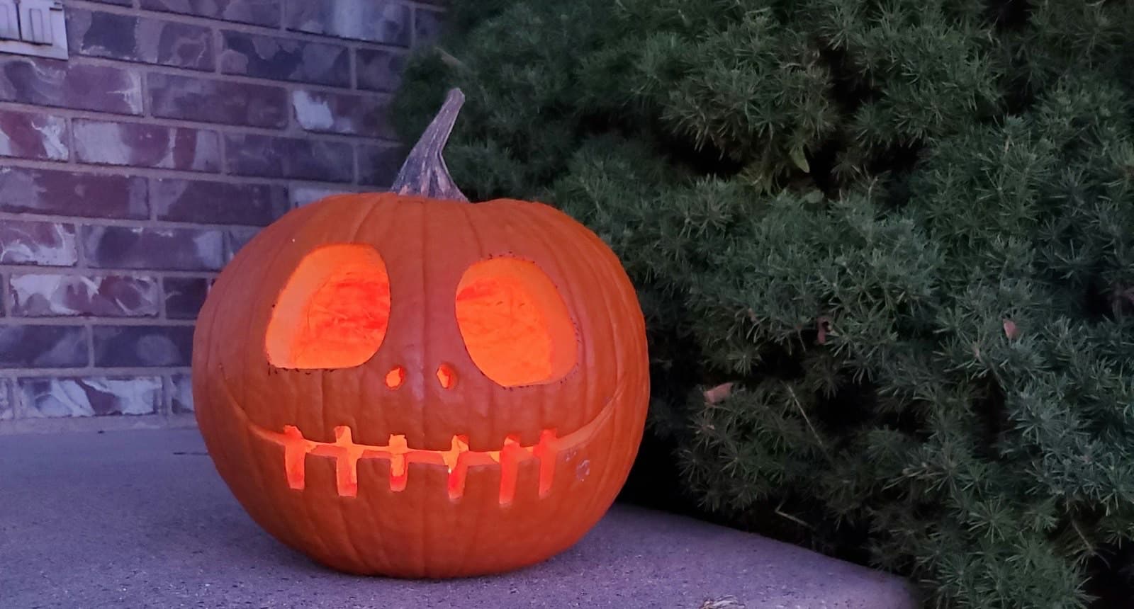 A carved jack-o-lantern glowing on a step